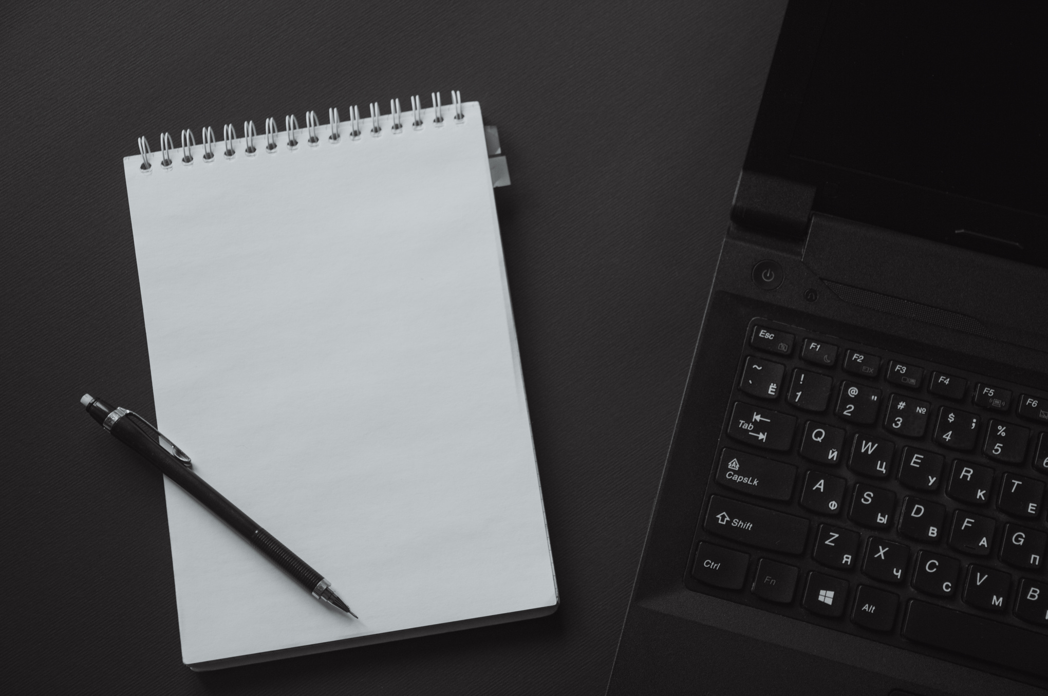 Black Laptop Computer Beside White Steno Notebook